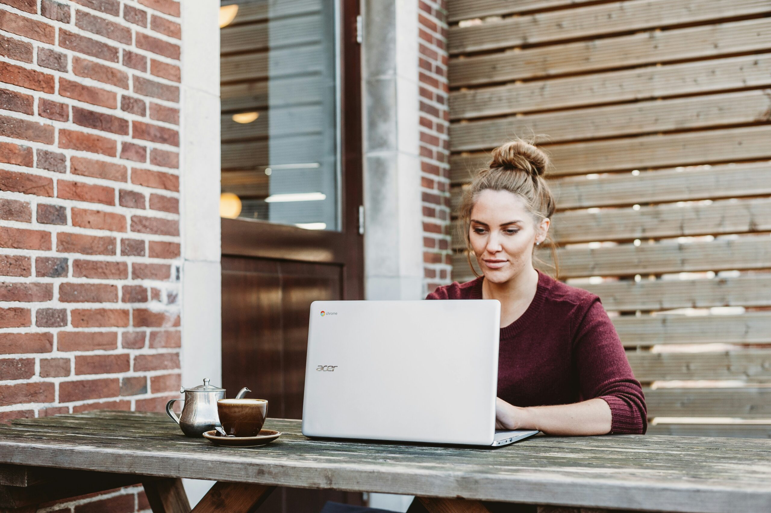 woman sitting and holding white acer laptop